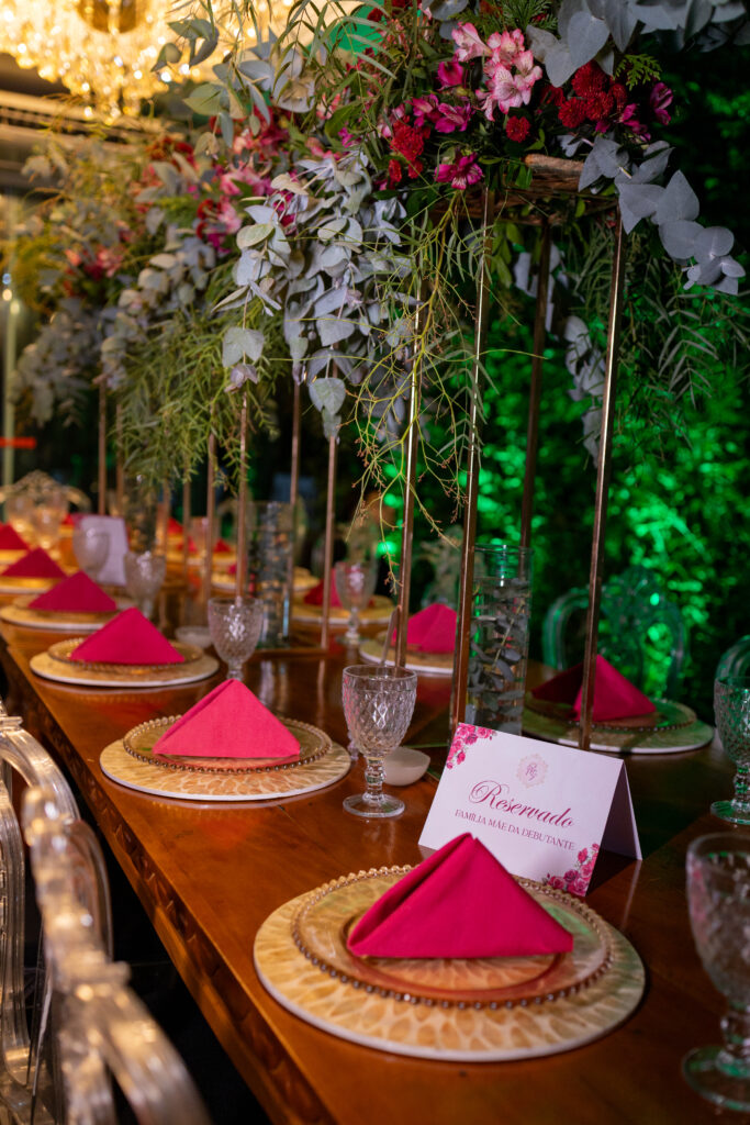 Mesa dos convidados com arranjos altos e guardanapos em tom de pink