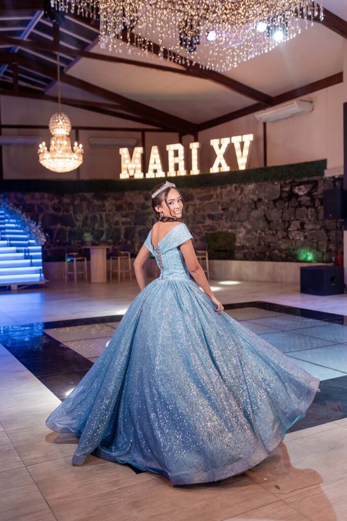 Debutante roda o vestido azul diante do letreiro luminoso
