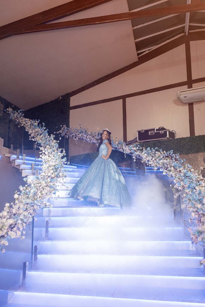 Debutante no alto da escadaria iluminada com efeito de fumaça