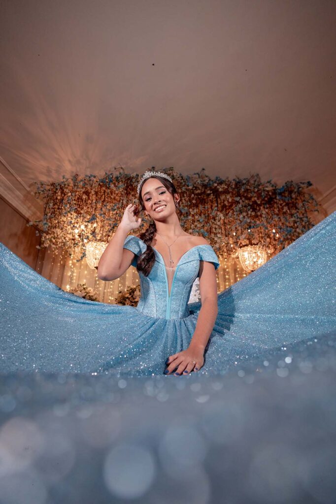 Debutante sentada com o vestido azul espalhado ao redor