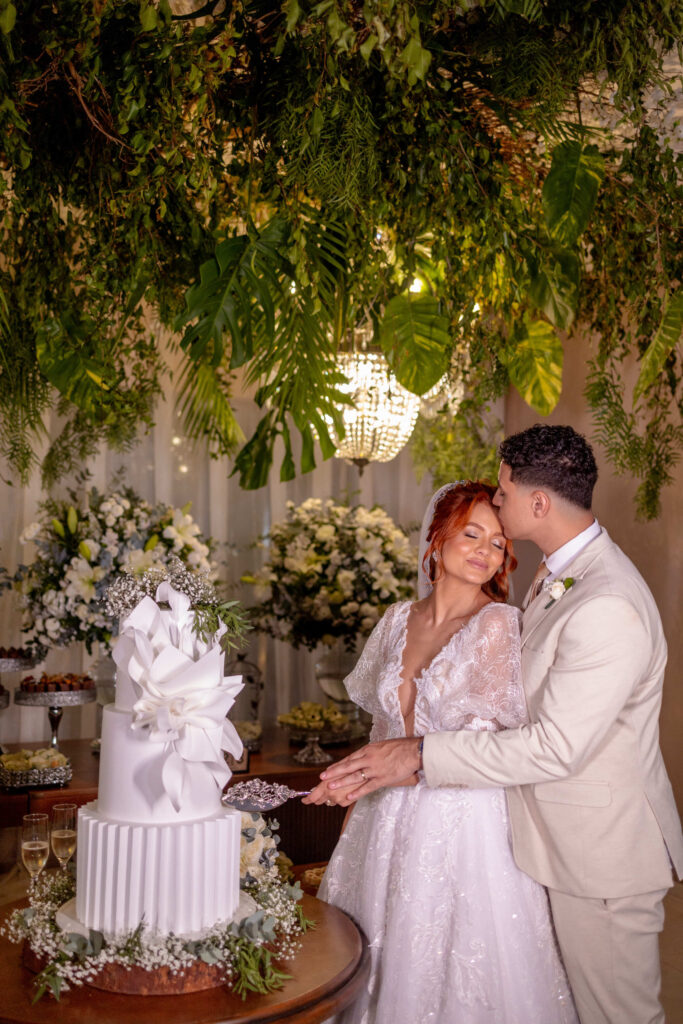 Noivos diante do bolo de casamento em branco