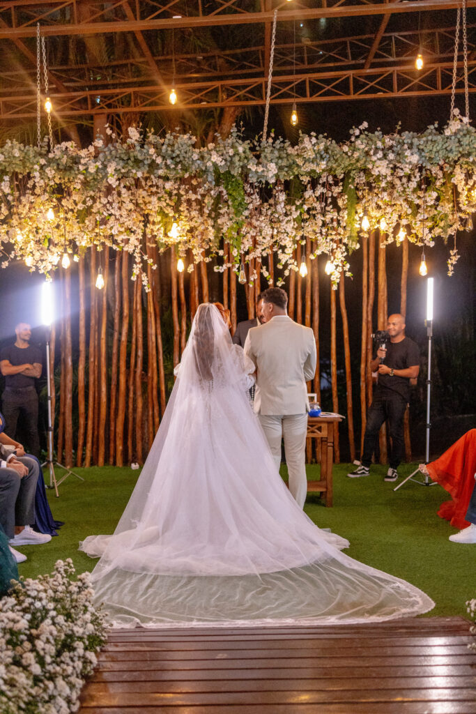 Noiva de costas no altar com a cauda do vestido estendida