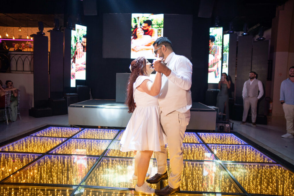 Noivos se abraçam na pista durante a festa de casamento