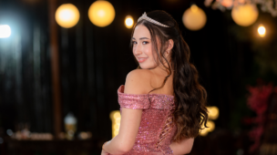 Debutante em vestido rosé sob a decoração de flores brancas e lanternas
