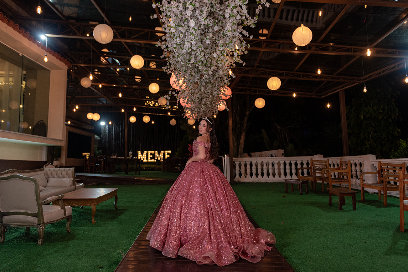 Debutante em vestido rosé no lounge externo decorado com flores brancas suspensas