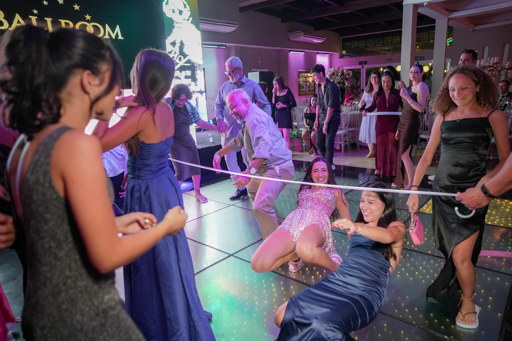 Convidados brincam de limbo durante a animação da festa