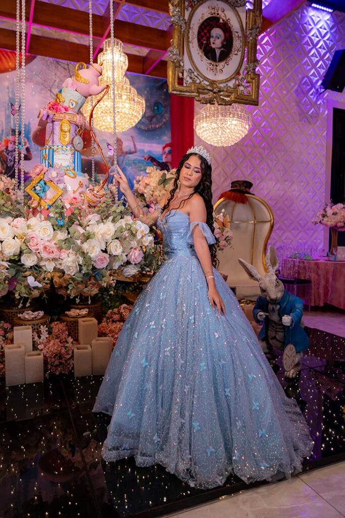 Debutante em vestido azul diante da decoração em tons pastel