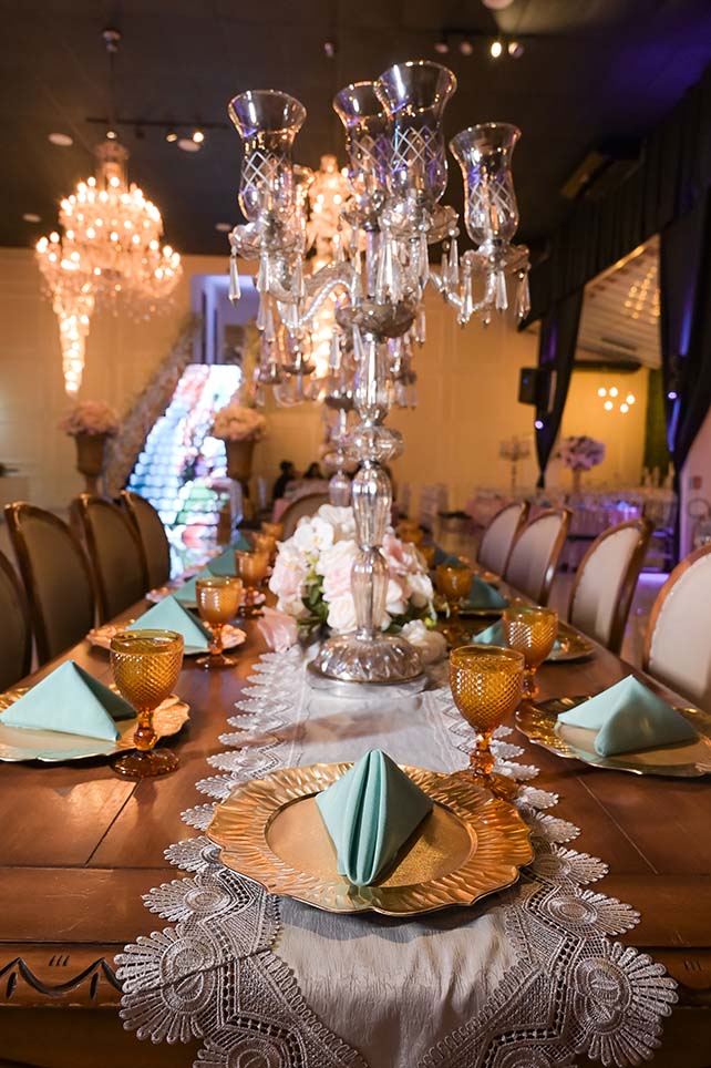 Mesa dos convidados com candelabros de cristal e guardanapos verdes