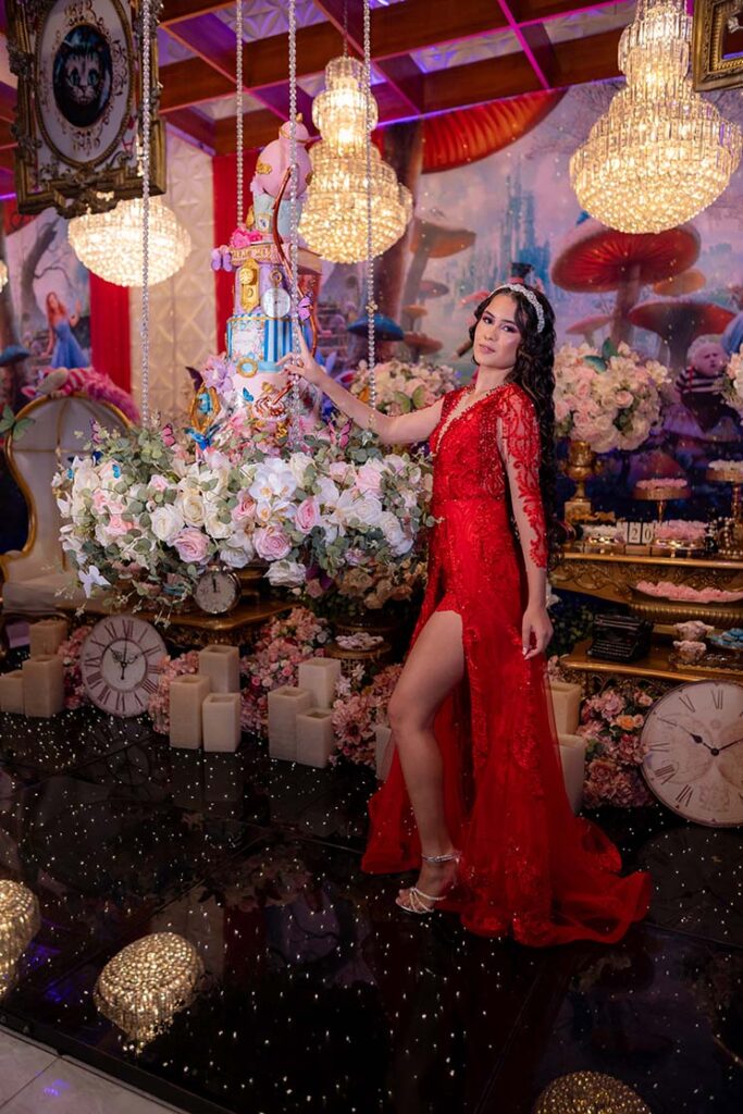Debutante no segundo look vermelho sob as luminárias suspensas