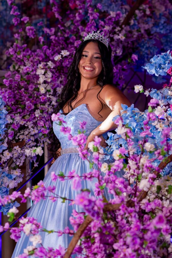 Debutante emoldurada por flores em tons de rosa e lilás