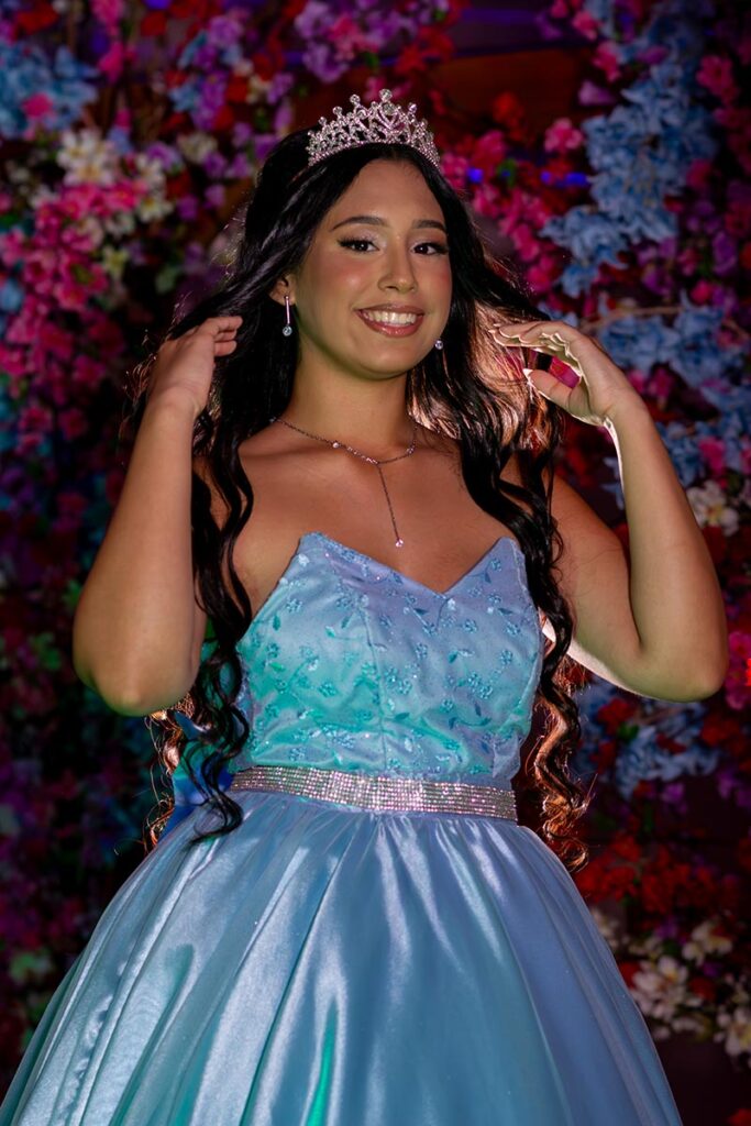 Retrato da debutante com coroa diante das flores da decoração