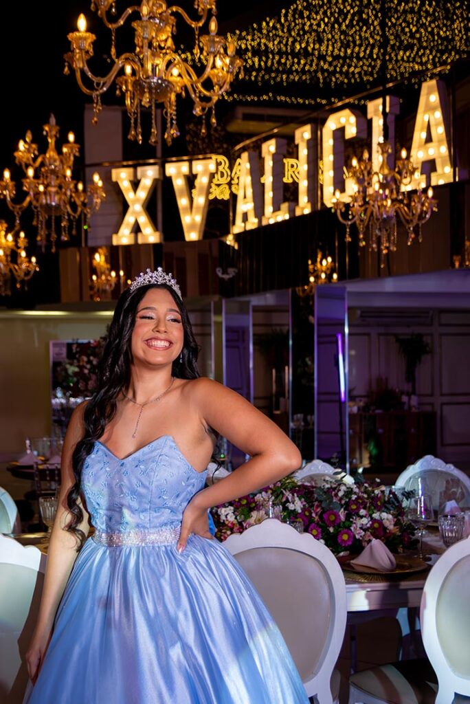 Debutante em vestido azul no salão decorado com lustres de cristal