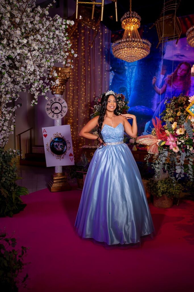 Debutante em vestido azul diante da decoração com relógio de parede