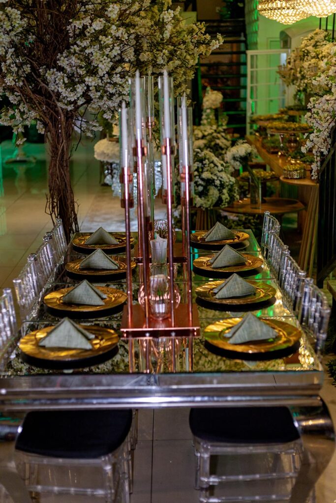 Mesa dos convidados com sousplats dourados e taças de cristal