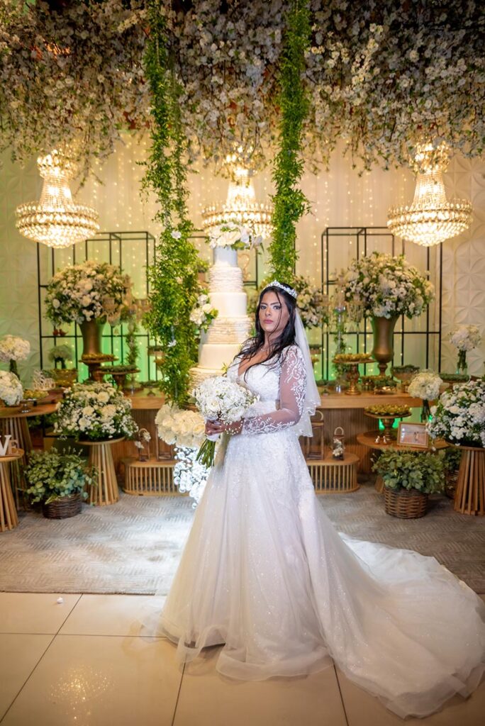 Noiva em vestido de renda diante da decoração de flores brancas