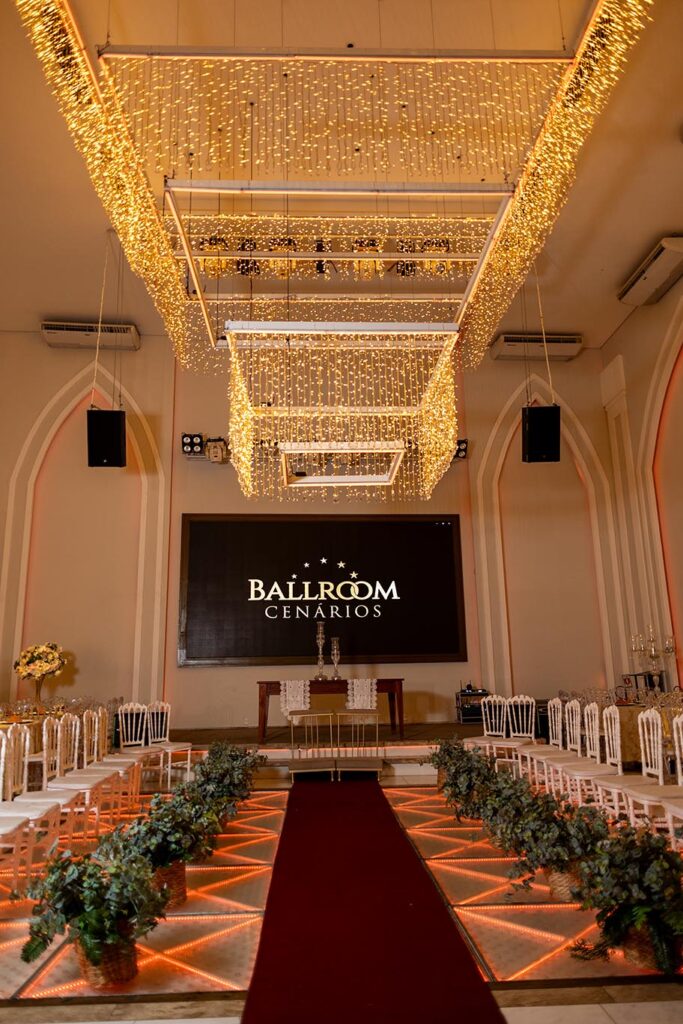 Cerimônia de casamento montada com tapete vermelho e teto de luzes douradas