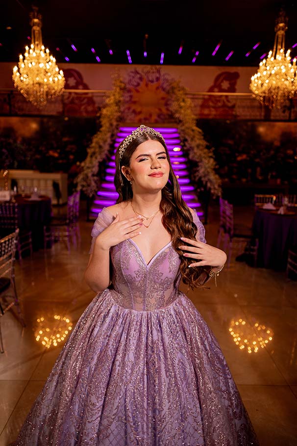 Debutante em vestido lilás diante da escadaria iluminada em roxo