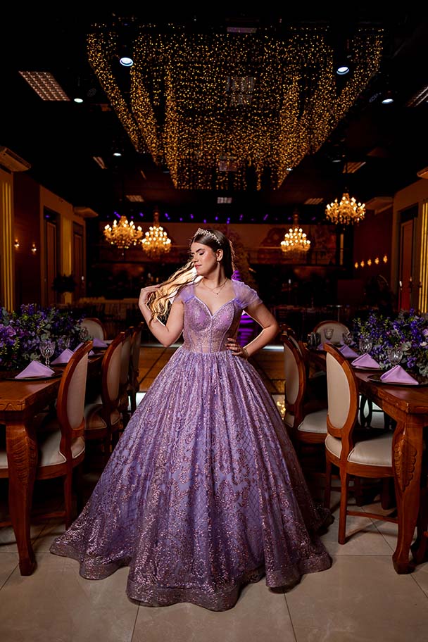 Debutante em vestido lilás sob os lustres de cristal