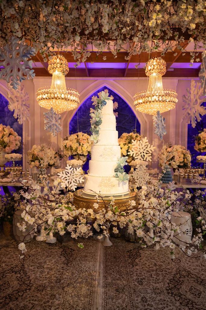 Bolo de 15 anos em branco emoldurado por flores e flocos de neve