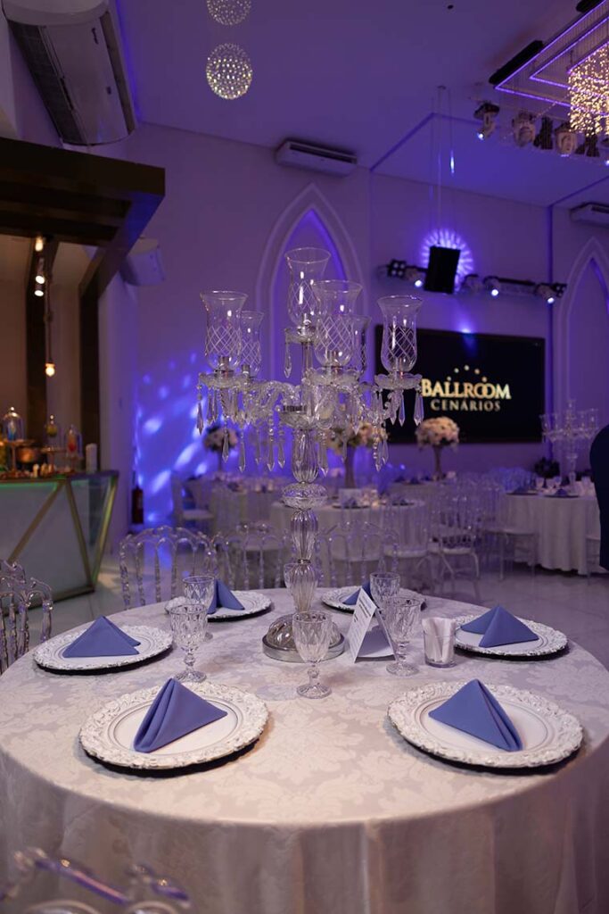 Mesa dos convidados com guardanapos azuis e taças de cristal