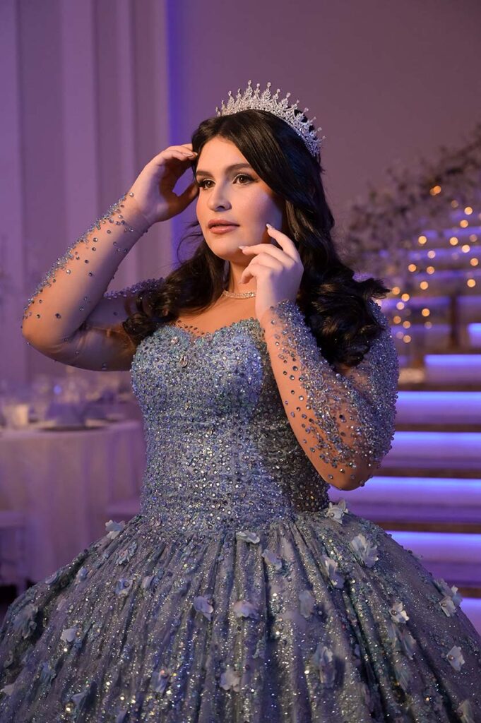 Retrato da debutante com coroa e vestido azul bordado