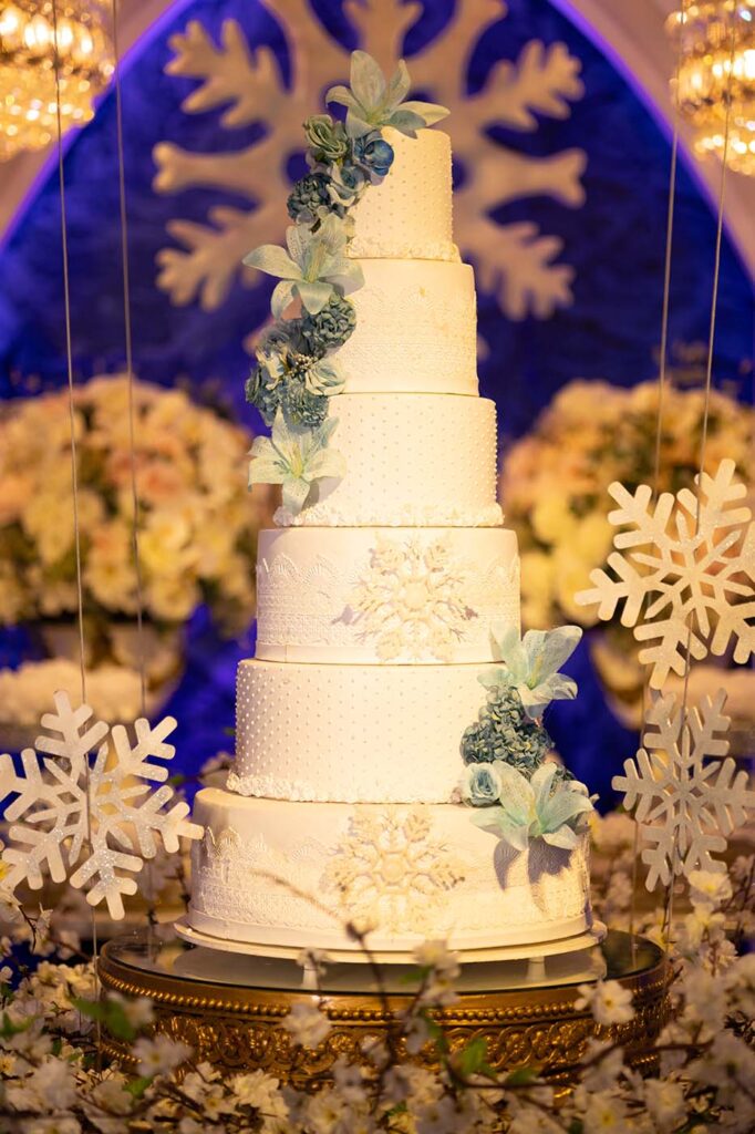 Bolo de 15 anos em branco decorado com flocos de neve e flores