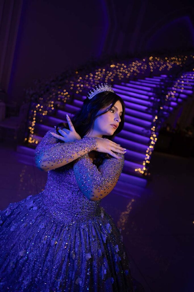 Debutante em vestido azul sob a iluminação azul do salão