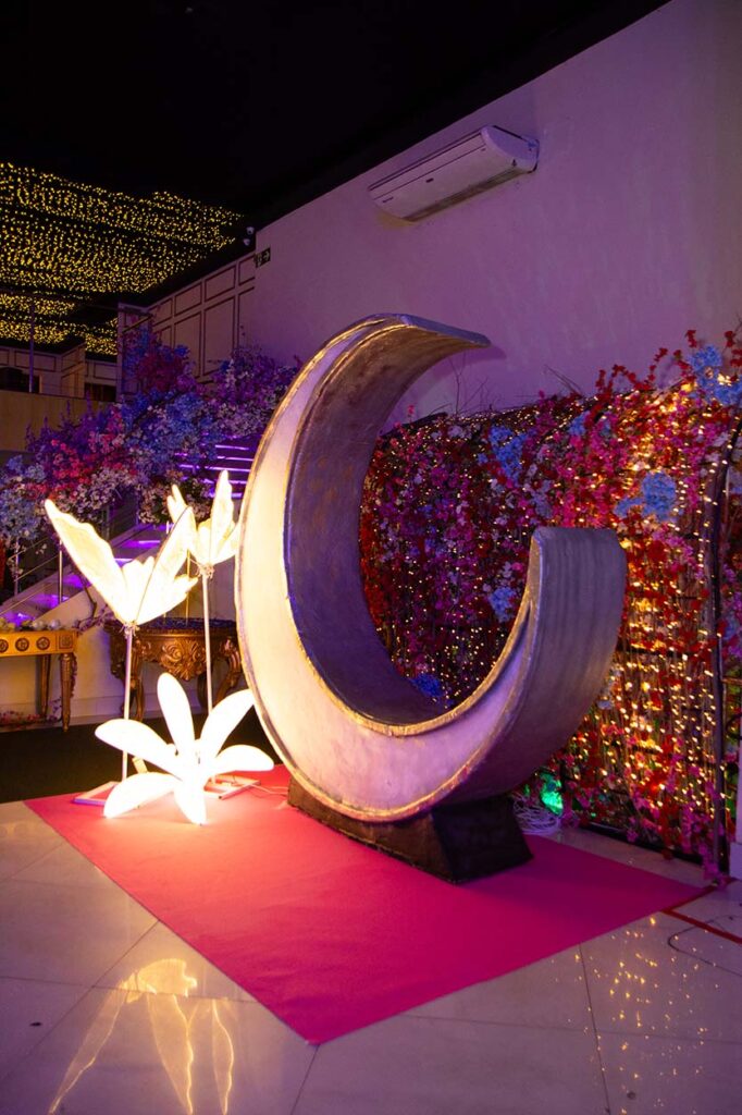 Cenário com lua decorativa iluminada sobre tapete vermelho