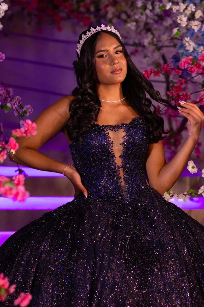 Debutante em vestido roxo entre arranjos de flores