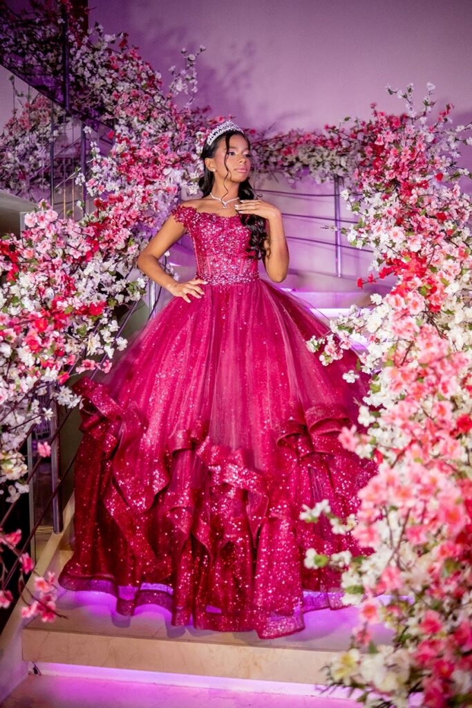 Mariana em vestido pink na escadaria decorada com flores