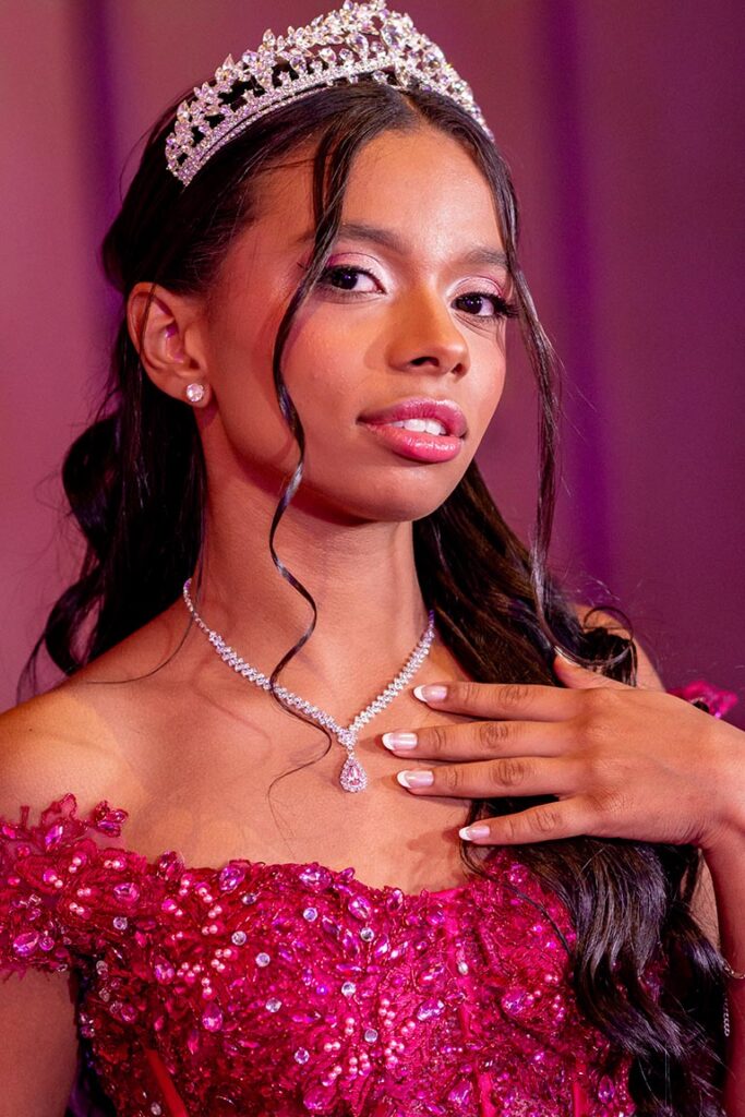 Retrato aproximado da debutante com tiara e vestido pink bordado