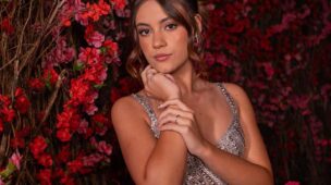 Retrato da debutante entre as flores vermelhas da decoração