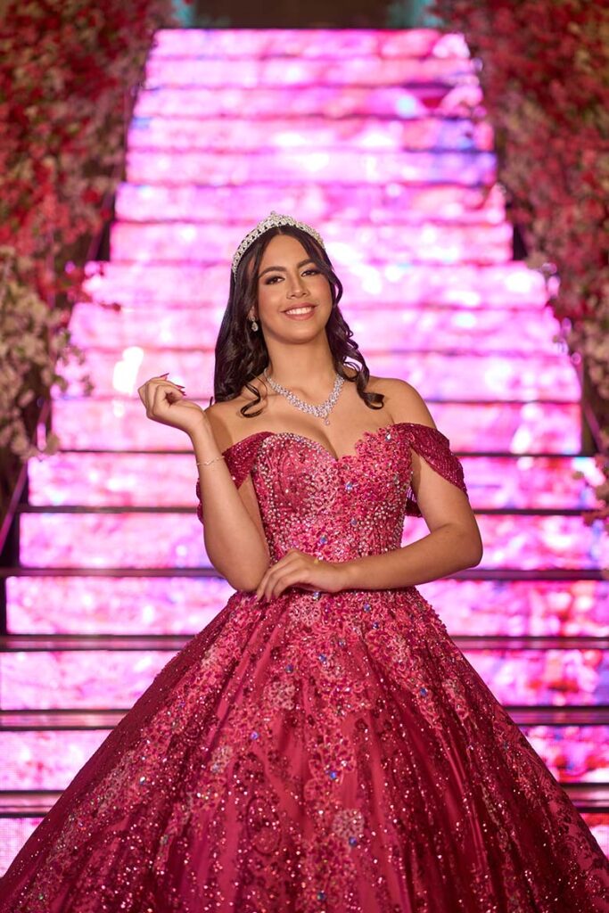 Debutante em vestido pink sentada na escadaria de LED