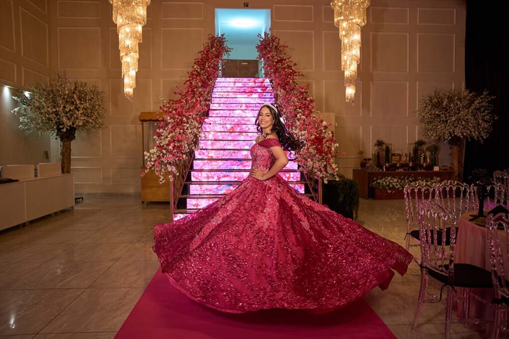 Debutante em vestido pink com a saia estendida no salão
