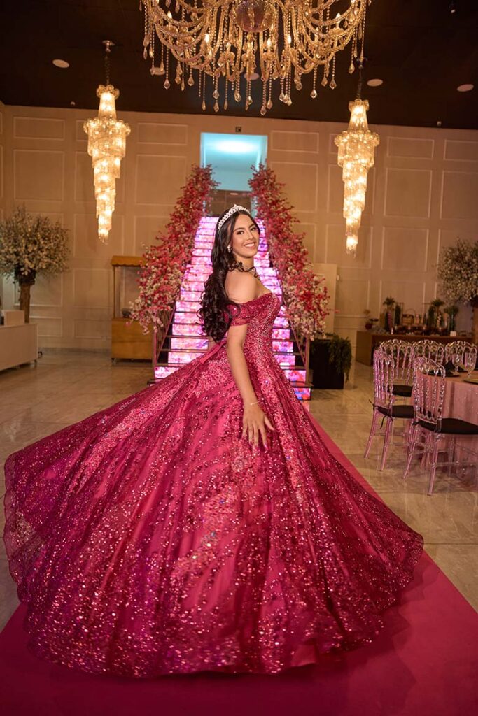 Debutante em vestido pink diante dos lustres de cristal