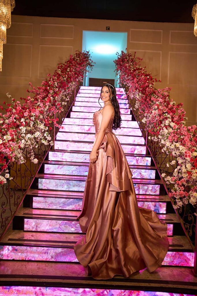 Debutante no segundo look diante da escadaria de LED