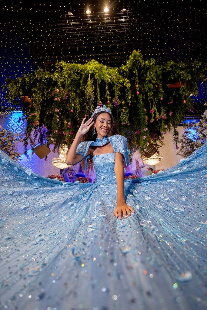 Debutante em vestido azul com a saia estendida no cenário