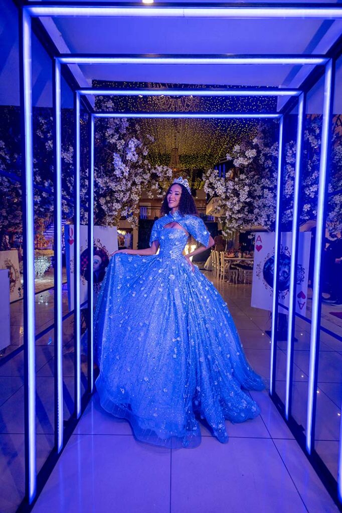 Debutante em vestido azul no túnel de luzes azuis