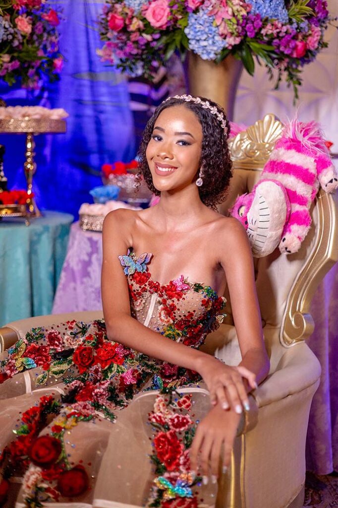 Debutante no segundo look floral sentada entre as flores