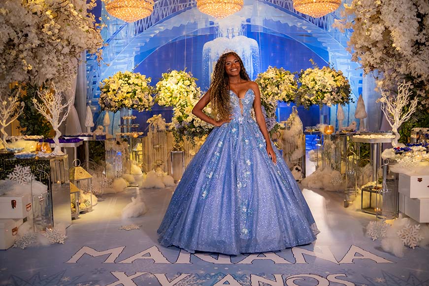 Debutante em vestido azul no centro do cenário do inverno encantado
