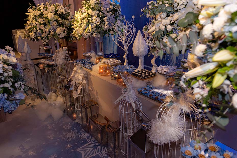 Mesa de doces decorada com flores brancas e peças em cristal