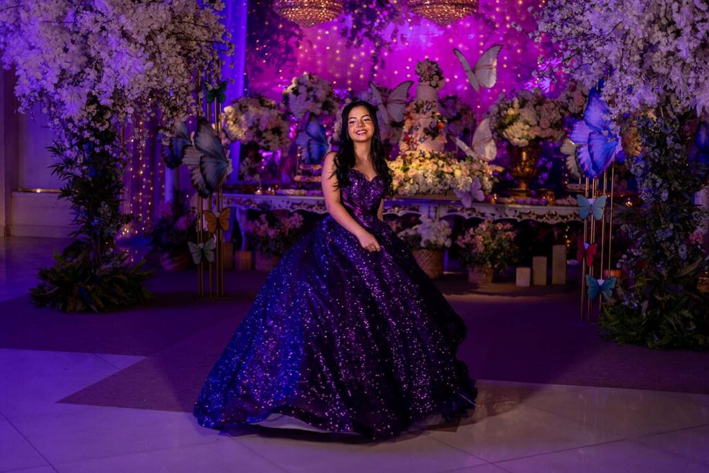 Debutante em vestido roxo no centro do cenário iluminado