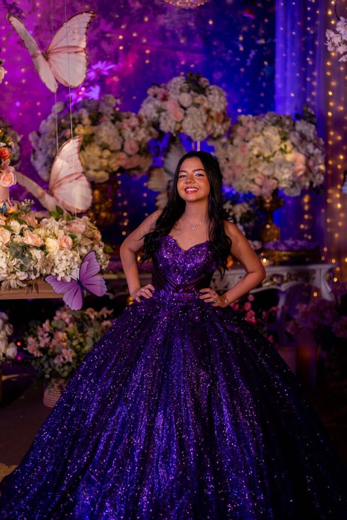 Debutante em vestido roxo entre as borboletas decorativas