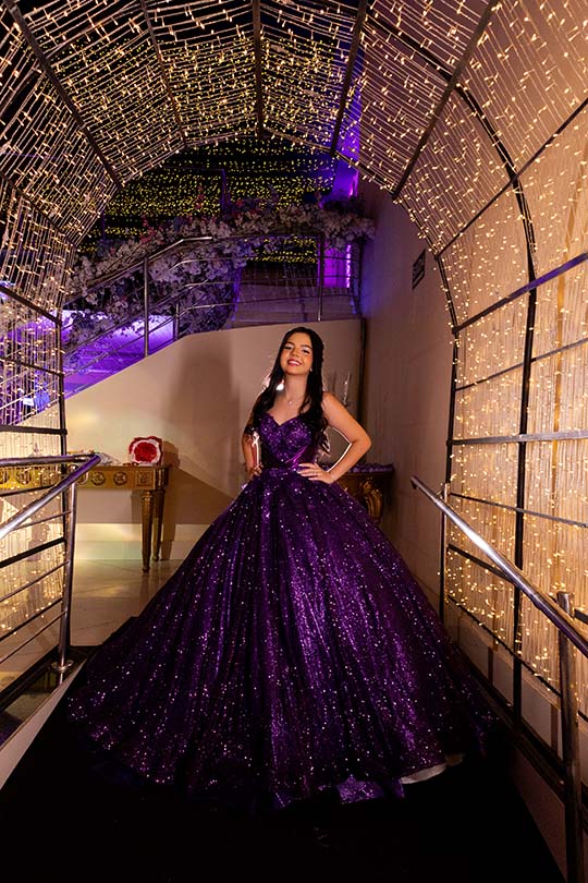 Debutante em vestido roxo no túnel de luzes da entrada