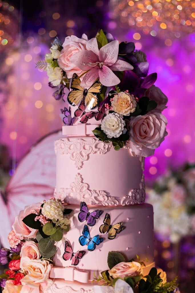 Detalhe do bolo de 15 anos decorado com borboletas e flores