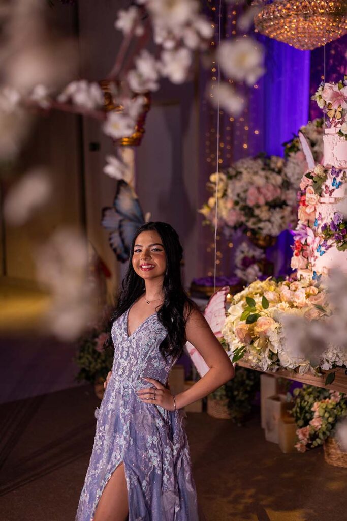 Debutante no segundo look prateado entre as flores da decoração