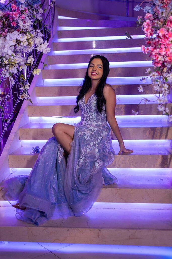 Debutante no segundo look sentada na escadaria iluminada