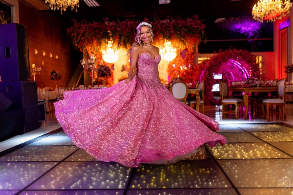 Debutante roda o vestido rosa na pista iluminada