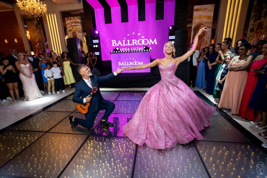 Debutante dança na pista diante do painel com o nome da casa de festas