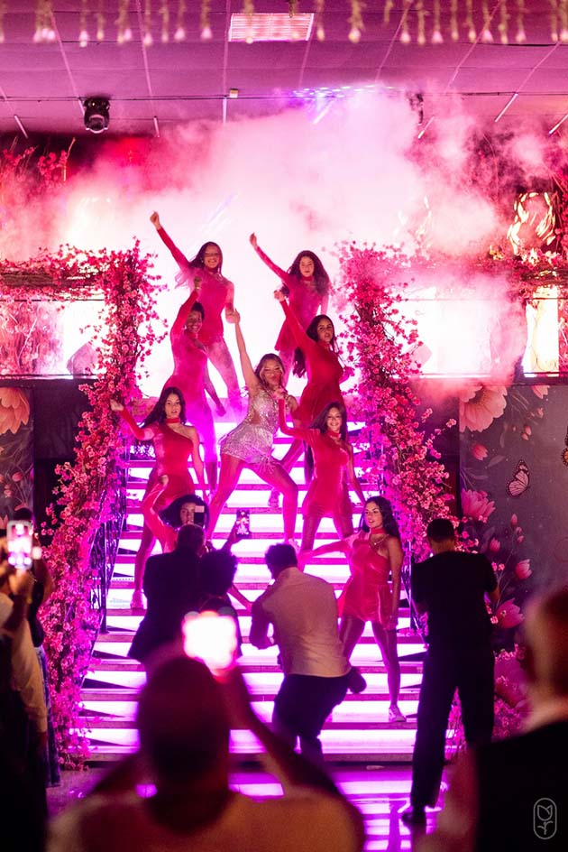 Dançarinos se apresentam na escadaria iluminada em rosa